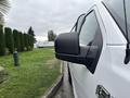 A white 2020 Ford F-150 with a side view mirror prominently displayed in the foreground