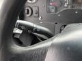 A close-up of the steering column in a 2012 Ford Econoline showing the windshield wiper control and headlight switch