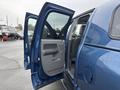 A blue 2006 Dodge Ram 2500 with its front door open, showing the interior and seating area