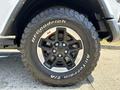Close-up of a black alloy wheel with a rugged tire labeled BFGoodrich All-Terrain T/A mounted on a 2021 Jeep Wrangler