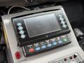 Control panel with various buttons and a blank display screen on a vehicle's dashboard