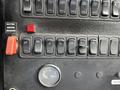 Close-up of a control panel featuring various switches and knobs including a gauge labeled water and a light indicator showing 142 degrees