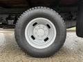 A close-up of a silver wheel with a six-bolt pattern mounted on a rugged black tire designed for a 2008 Ford F-350