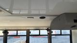 Interior view of a 2021 Ford Transit showing overhead storage and ceiling features with a light and speaker mounted above the windows