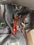 A close-up view of the wiring and electronic components inside a 2018 Chevrolet Express including red and black wires and connectors