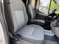 Interior of a 2022 Ford Transit showing two gray front seats with textured fabric and a steering wheel visible in the foreground