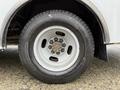 A close-up view of the wheel of a 2020 Chevrolet Express showing a silver rim and a black tire with a tread pattern