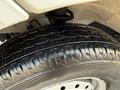 Close-up of a tire from a 2008 Suzuki Carry showing tread pattern and slight moisture on the surface