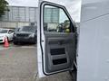 A 2017 Ford Econoline van with an open driver's side door showing the interior panel and handle