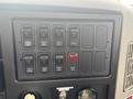 Interior dashboard panel of a 2012 International 7300 Workstar featuring multiple toggle switches and a warning light