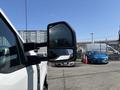 A 2023 Ford F-350 SD side mirror reflecting a nearby vehicle with a clear view of the mirror's design and structure