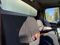 Interior view of a 2012 Freightliner M2 106 cab showcasing the black fabric bench seat and seatbelt on the driver's side