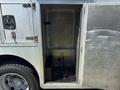 An open metal storage compartment of a 2008 Workhorse W62 showing a flat floor and black tool holders inside