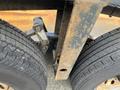 Close-up of the dual tires and undercarriage of a 2013 JLG Industries 1014 showing rugged tread patterns and a rusted metal frame
