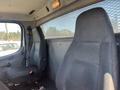 Interior of a 2007 Freightliner M2 106 featuring two fabric-covered seats in the cab area with a safety partition behind them