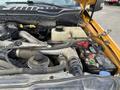 A close-up view of the engine bay of a 2017 Ford F-250 SD showing the components including the battery and cooling system parts