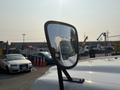 A side mirror of a 2009 Ford F-550 reflecting the vehicle itself in the mirror glass
