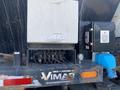 A 2014 International 7400 featuring a silver control box with multiple hydraulic connections and a blue component attached to the side