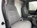 Interior of a 2022 Ford Econoline featuring two gray upholstered front seats and a central console between them