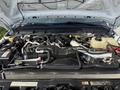 Engine compartment of a 2015 Ford F-550 showing the engine and various mechanical components including hoses and a coolant reservoir