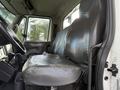 The image shows the interior of a 2010 International 4300 with two large leather seats in the foreground and a gear shift nearby