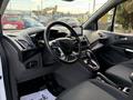 Interior view of a 2020 Ford Transit Connect showcasing the steering wheel dashboard and front seating area