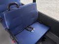 A blue upholstered seat with a safety belt attached, designed for a van or bus interior
