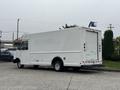 2012 Ford E-450 Super Duty delivery truck with a white exterior and rear roll-up door parked at an angle