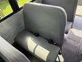Interior view of a 2011 Freightliner B2 featuring gray vinyl seating with safety seatbelts attached