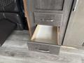 A partially opened drawer in a 2021 Jayco Jay Flight camper showcasing a wooden interior with no contents inside