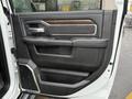The interior door panel of a 2024 RAM 5500 featuring leather accents a wood grain insert and control buttons for windows and locks