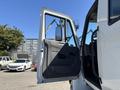 A white 2011 International 4300 truck with an open driver's door revealing the cabin interior and side mirror