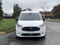 A 2019 Ford Transit Connect facing forward with a white exterior and a large front grille showcasing the Ford logo