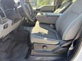 A 2017 Ford F-350 SD interior showing the driver's seat and armrest with fabric upholstery and a floor mat