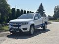 A white 2017 Chevrolet Colorado pickup truck with a blue utility bed and off-road accessories parked on a street