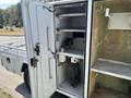 A 2017 Ford F-550 with an open utility storage compartment featuring shelves and hooks for tools and equipment
