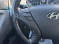 Close-up of the steering wheel of a 2014 Hyundai Sonata featuring controls for volume and mode
