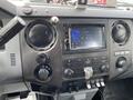 Interior dashboard of a 2015 Ford F-550 featuring audio controls a display screen and knobs for climate and media settings