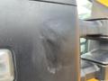 Close-up of a 2017 Ford F-250 SD side mirror showing a scuff mark on the black surface with a light reflection and water droplets