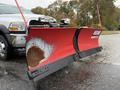 A 2012 Dodge Ram 5500 with a large red snowplow attached to the front showing signs of wear and rust on the blade