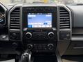 Interior dashboard of a 2018 Ford F-150 featuring a central touchscreen display with audio and climate controls and various buttons and knobs