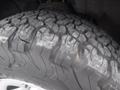 Close-up of a rugged tire from a 2015 Chevrolet Silverado 1500 showcasing a detailed tread pattern designed for off-road performance