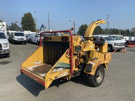 A yellow 2010 Vermeer Corporation BC1200XL wood chipper with a feed chute large enough for branches and a trailer hitch at the back