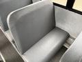 A grey bench seat from a 2014 Freightliner B2 with a smooth surface and a simple design