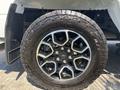 Close-up of a 2021 Ford F-150 wheel featuring a black and chrome alloy rim and rugged all-terrain tire