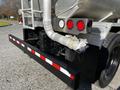 A 2013 Kenworth T370 with a metallic tanker trailer featuring red brake lights and a black bumper with reflective stripes