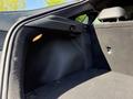 The image shows the interior trunk space of a 2024 Kia Forte5 with a black cloth lining and a small light integrated into the side of the trunk compartment
