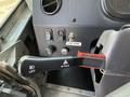 Interior view of a 2017 Freightliner MT45 dashboard featuring a lift lever labeled with an 'E' and a pull switch for hazards along with a cow horn switch
