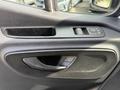 Interior door panel of a 2023 Mercedes-Benz Sprinter featuring a window control switch and door handle
