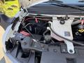 A 2020 Chevrolet Express engine compartment showing the exposed engine components including the battery coolant reservoir and various wires and connections
